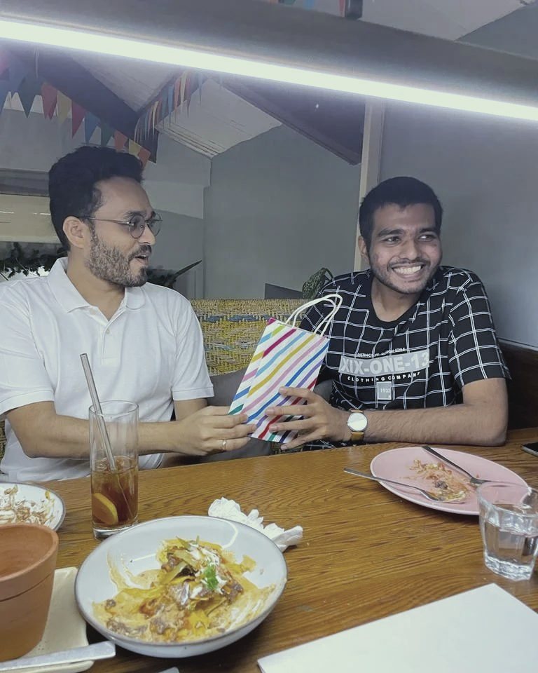 Saajan handing a teammate a gift